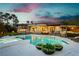 Inviting backyard featuring a sparkling pool, spa, outdoor kitchen, and lush landscaping at 19 Isleworth Dr, Henderson, NV 89052