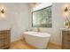 Modern bathroom featuring a soaking tub, large window, and stylish fixtures at 19 Isleworth Dr, Henderson, NV 89052