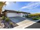 Expansive driveway leading to a modern home with lush landscaping at 19 Isleworth Dr, Henderson, NV 89052