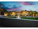 Stunning single story home with lush landscaping, pathway, and unique architecture highlighted at twilight at 19 Isleworth Dr, Henderson, NV 89052