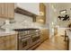 Chef's kitchen with a large stainless steel range, custom cabinetry, and marble countertops at 19 Isleworth Dr, Henderson, NV 89052