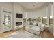 Cozy living room with a fireplace, large windows, and a comfortable sectional sofa at 19 Isleworth Dr, Henderson, NV 89052