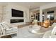 Sophisticated living room with a stone fireplace, large screen TV, and comfortable seating arrangement at 19 Isleworth Dr, Henderson, NV 89052