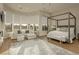 Spacious main bedroom featuring a sitting area, a four-poster bed, and large windows at 19 Isleworth Dr, Henderson, NV 89052
