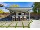 Stylish outdoor bar featuring modern countertops, a covered pergola, a TV, and four comfortable bar stools at 19 Isleworth Dr, Henderson, NV 89052