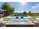 Backyard oasis with swimming pool, lush landscaping, and outdoor entertaining area with fire pit at 19 Isleworth Dr, Henderson, NV 89052