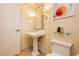 Elegant powder room with a pedestal sink, decorative mirror, modern fixtures, and sophisticated wallpaper at 2000 Fashion Show Dr # 3526, Las Vegas, NV 89109