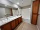 Bathroom featuring dual sinks, wood cabinets, and a shower-tub combo at 2105 William Holden Ct, Las Vegas, NV 89142
