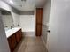 Bathroom featuring wood cabinets, a shower-tub combo, and tile flooring at 2105 William Holden Ct, Las Vegas, NV 89142