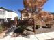 View of home with mature tree, brick wall, and landscaping, offering privacy at 2105 William Holden Ct, Las Vegas, NV 89142