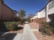 Landscaped walkway between two houses showcasing neat hedges and gravel ground cover at 2105 William Holden Ct, Las Vegas, NV 89142