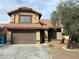 Two-story home featuring a red tile roof and a two-car garage, complimented by well-kept landscaping in front at 228 Moose Ln, Las Vegas, NV 89145
