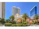Impressive building entrance with lush landscaping, a porte-cochere, and towering palm trees at 2877 Paradise Rd # 104, Las Vegas, NV 89109