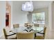 Elegant dining room featuring a modern chandelier, glass table, and comfortable seating with outdoor view at 2877 Paradise Rd # 104, Las Vegas, NV 89109
