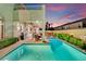 A pristine backyard features a pool, covered patio with dining area and manicured landscaping at 296 Brushy Creek Ave, Las Vegas, NV 89148