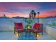 Inviting balcony with cozy seating and a scenic view of palm trees and the surrounding neighborhood at sunset at 296 Brushy Creek Ave, Las Vegas, NV 89148