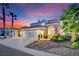 Beautiful two-story home with a three-car garage, arched entryway, and lush landscaping against a vibrant sunset sky at 296 Brushy Creek Ave, Las Vegas, NV 89148