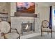 Close-up of the fireplace with a stone surround, decorative screen, and comfortable chairs at 296 Brushy Creek Ave, Las Vegas, NV 89148