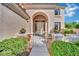 Charming front entrance with an arched walkway, decorative planters, and manicured bushes at 296 Brushy Creek Ave, Las Vegas, NV 89148
