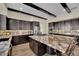 Modern kitchen with dark wood cabinets, a large granite island, and stainless steel appliances at 296 Brushy Creek Ave, Las Vegas, NV 89148