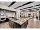 Island kitchen with granite counters and dark wood beam ceiling views the living room at 296 Brushy Creek Ave, Las Vegas, NV 89148