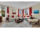 Bright living room with large windows, red curtains, and neutral furniture at 296 Brushy Creek Ave, Las Vegas, NV 89148