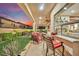 Covered patio with chairs, backyard view, and a convenient kitchen window servery at 296 Brushy Creek Ave, Las Vegas, NV 89148