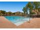 Community swimming pool with lounge seating surrounded by wrought iron fence at 296 Brushy Creek Ave, Las Vegas, NV 89148