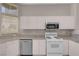 Bright kitchen features white cabinets, granite countertops, stainless dishwasher, and tile flooring at 3097 Quail Crest Ave, Henderson, NV 89052