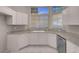 Bright kitchen features white cabinets, granite countertops, stainless dishwasher, and tile flooring at 3097 Quail Crest Ave, Henderson, NV 89052