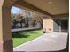 A covered patio overlooks the backyard that features manicured artificial turf and desert landscaping at 32 Feather Sound Dr, Henderson, NV 89052