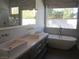 Modern bathroom with double sinks, a soaking tub, and natural light at 32 Feather Sound Dr, Henderson, NV 89052