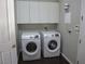 Convenient laundry room equipped with a washer, dryer, and overhead storage cabinets at 32 Feather Sound Dr, Henderson, NV 89052