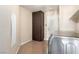 Functional laundry area featuring storage cabinet and modern washer, with access to the outdoors at 3305 Alcudia Bay Ave, Las Vegas, NV 89141