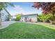 Well-maintained backyard with a lush green lawn, mature trees, and decorative water feature at 3365 Badura Ave, Las Vegas, NV 89118