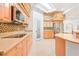 Kitchen area with mosaic backsplash, stainless steel appliances, and a corner sink at 3365 Badura Ave, Las Vegas, NV 89118