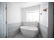 Bright bathroom with a soaking tub, large window, and neutral tile at 3369 Milenko Dr, Las Vegas, NV 89121
