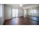 Bedroom with wood floors, mirrored closet doors, and access to an outdoor balcony at 3369 Milenko Dr, Las Vegas, NV 89121