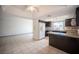 Open kitchen featuring dark wood cabinets, granite countertops, and a view into the adjacent living area at 3369 Milenko Dr, Las Vegas, NV 89121