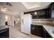 Open kitchen layout with dark cabinetry, granite countertops, stainless steel appliances, and access to bathroom at 3369 Milenko Dr, Las Vegas, NV 89121