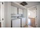 A convenient laundry room featuring a washer and dryer set with overhead storage cabinets and easy access to other rooms at 3369 Milenko Dr, Las Vegas, NV 89121