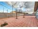Spacious backyard with tiled patio, mature trees and secure perimeter fencing at 4102 Calimesa St, Las Vegas, NV 89115