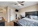 Modern bedroom featuring a dark-toned bed frame, wood-look floors, and a ceiling fan creates an inviting, calm space at 4102 Calimesa St, Las Vegas, NV 89115