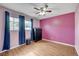 Bright bedroom with wood-look floors, two windows, and a ceiling fan with lighting at 4102 Calimesa St, Las Vegas, NV 89115
