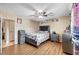 Bright bedroom with wood-look floors, ceiling fan, decorative headboard, dresser, and large window at 4102 Calimesa St, Las Vegas, NV 89115