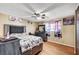 Comfortable bedroom with hardwood floors, a ceiling fan, and a decorative headboard with a window view at 4102 Calimesa St, Las Vegas, NV 89115