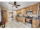 Open-concept kitchen featuring tile floors, natural wood cabinetry, and stainless steel appliances with an eat-in area at 4102 Calimesa St, Las Vegas, NV 89115