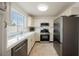 Bright kitchen features stainless steel appliances, white cabinets, and a large window over the sink at 430 Nancy Dr, Henderson, NV 89015