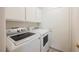 Functional laundry room with a full-size washer, dryer, cabinets, and exterior access at 430 Nancy Dr, Henderson, NV 89015