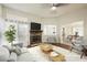Bright living room features a stone fireplace, ceiling fan, and views into kitchen and dining area at 430 Nancy Dr, Henderson, NV 89015
